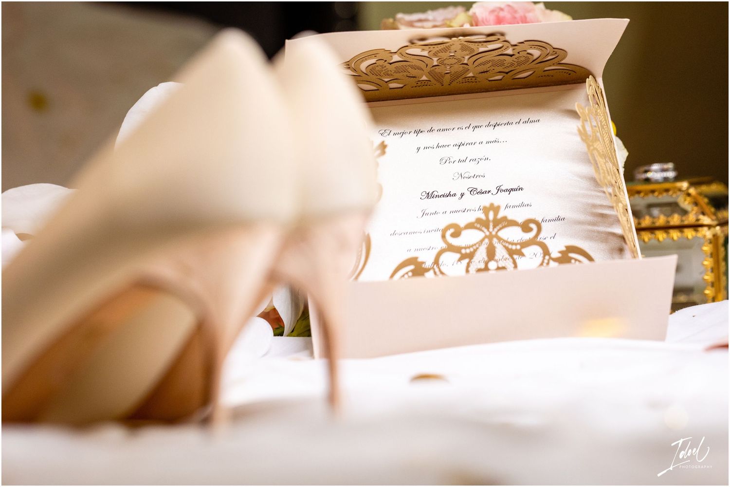Wedding stationery with gold crown motif and elegant heels in soft focus.