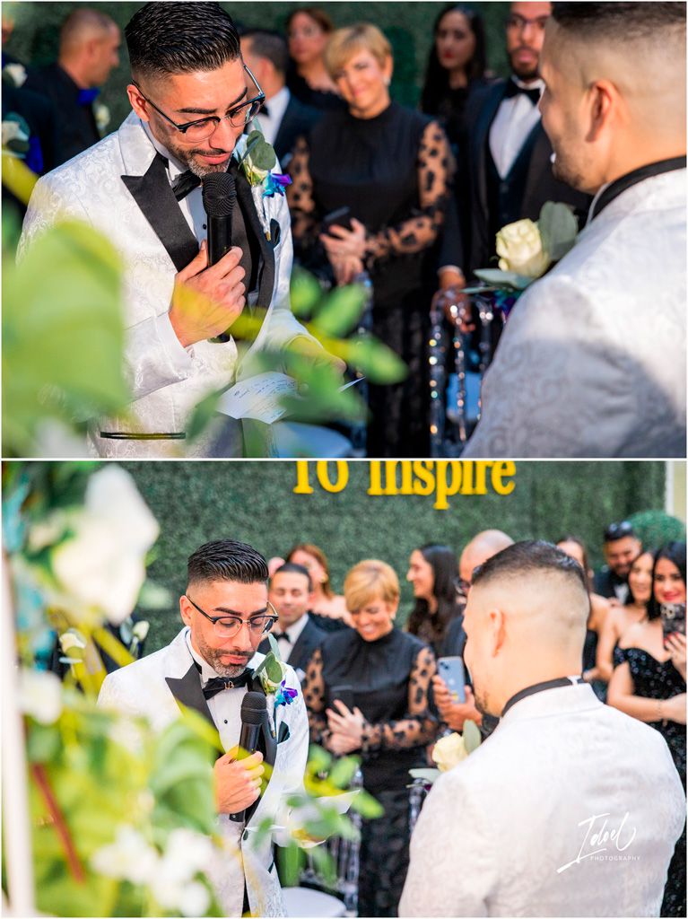 Two people in formal wedding attire sharing an emotional moment during an outdoor ceremony with guests watching.