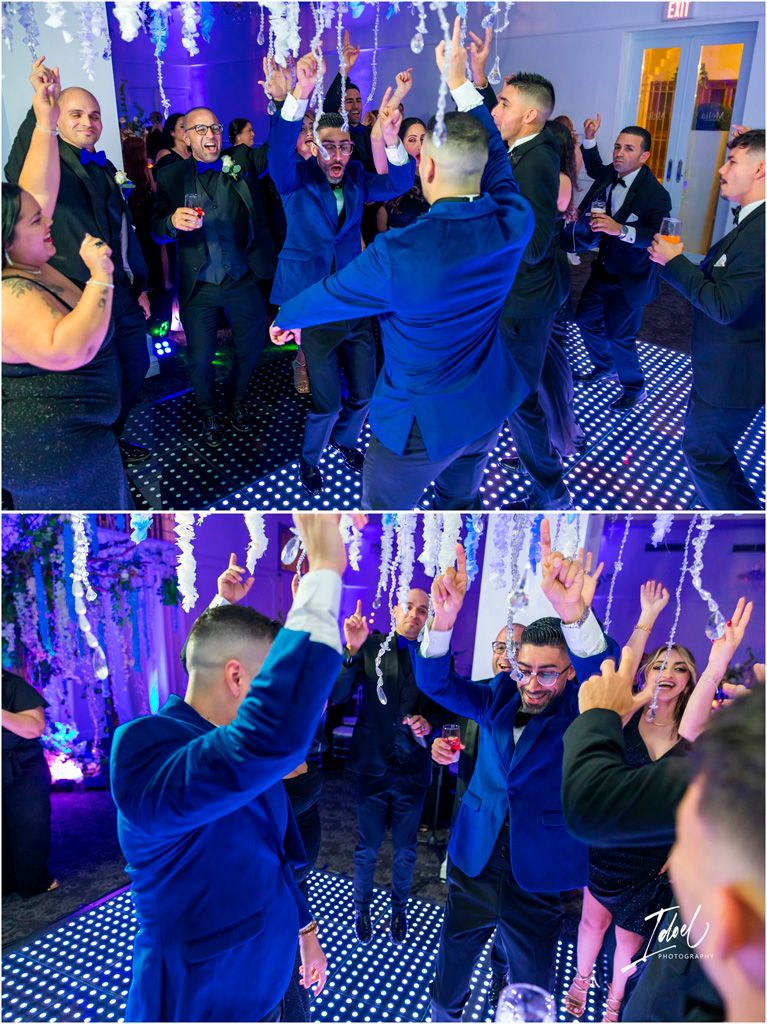 People dancing at a party with blue uplighting and black and white checkered floor.