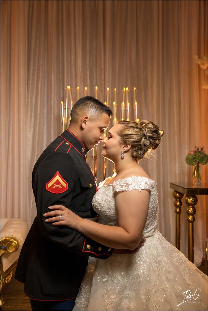 Intimate portrait of a couple in front of candlelit backdrop at their wedding reception.