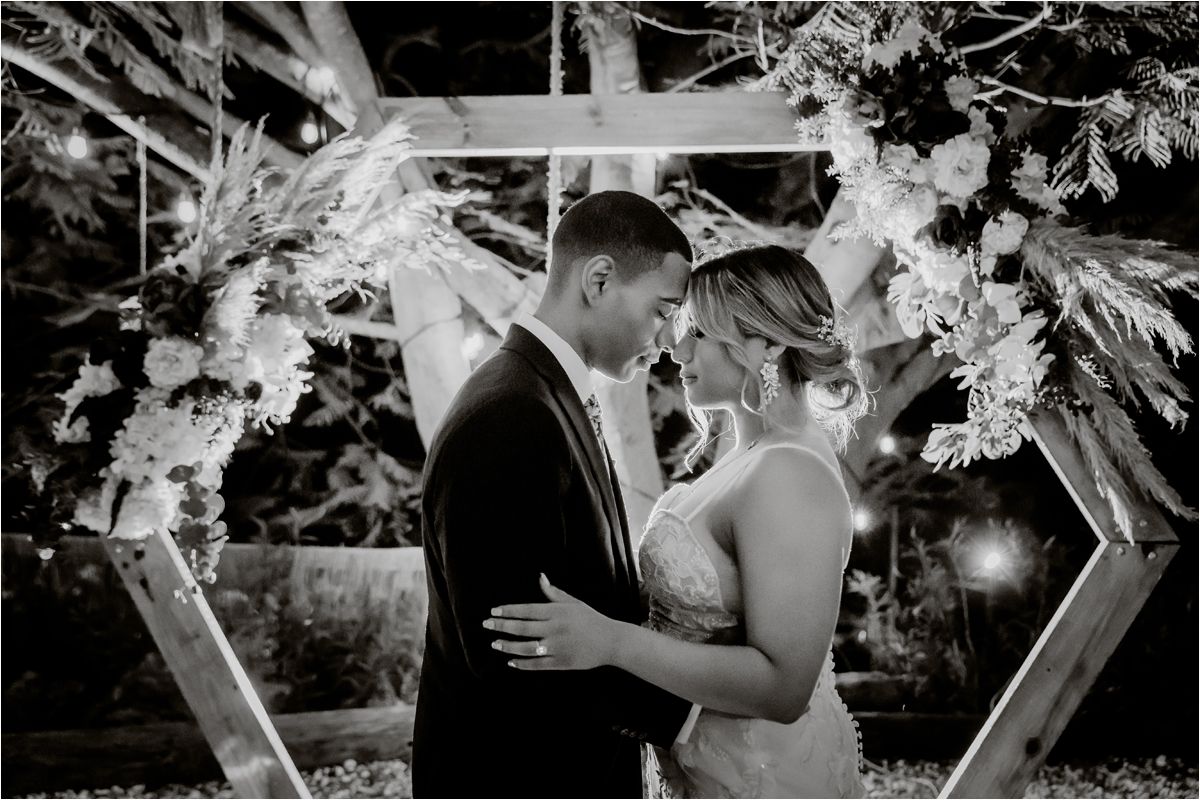 Black and white wedding ceremony moments captured under floral arch decorations.