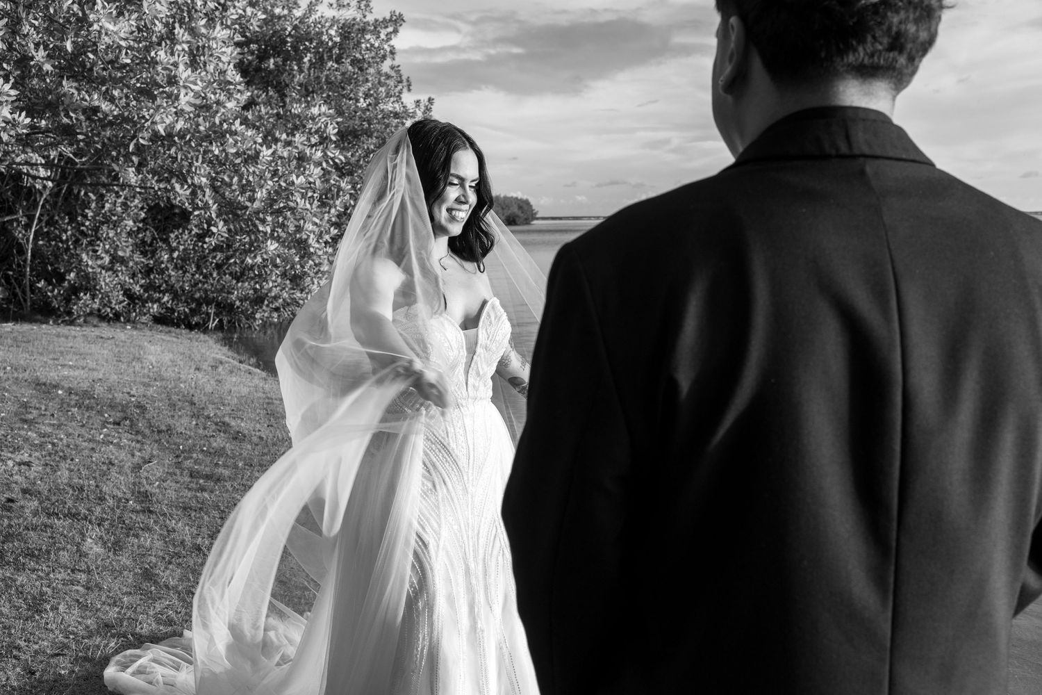 A black and white wedding photo sequence showing a couple in an outdoor setting with flowing veil.