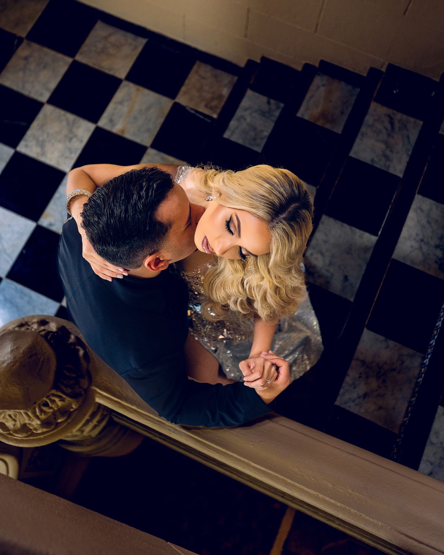 Romantic dance scene with elegant couple on black and white tiled floor.