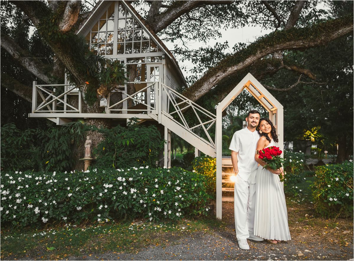 A romantic garden wedding sequence showing a couple walking through a flower-filled path at dusk.