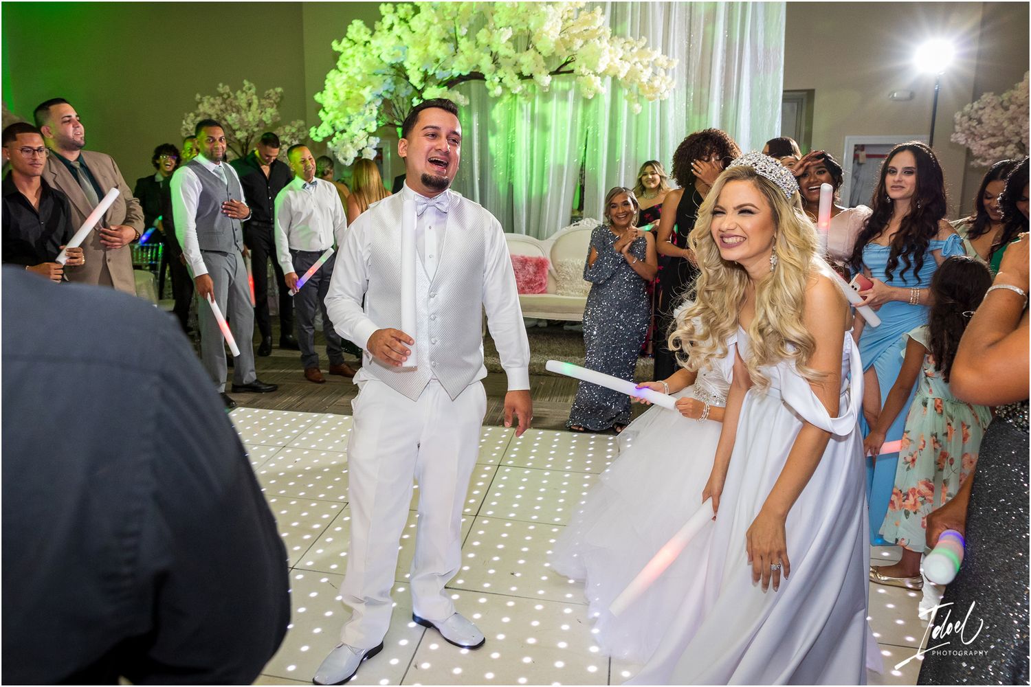 Wedding couple performing a choreographed dance routine on an illuminated dance floor.