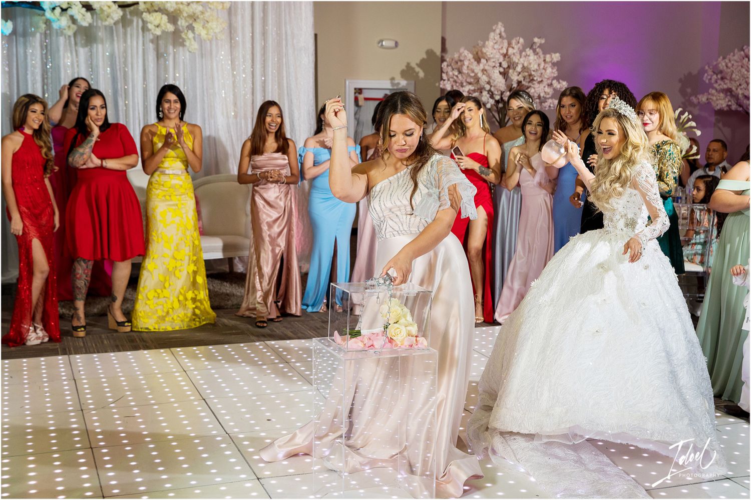 Wedding celebration with bridesmaids in colorful dresses watching a special moment on the dance floor.