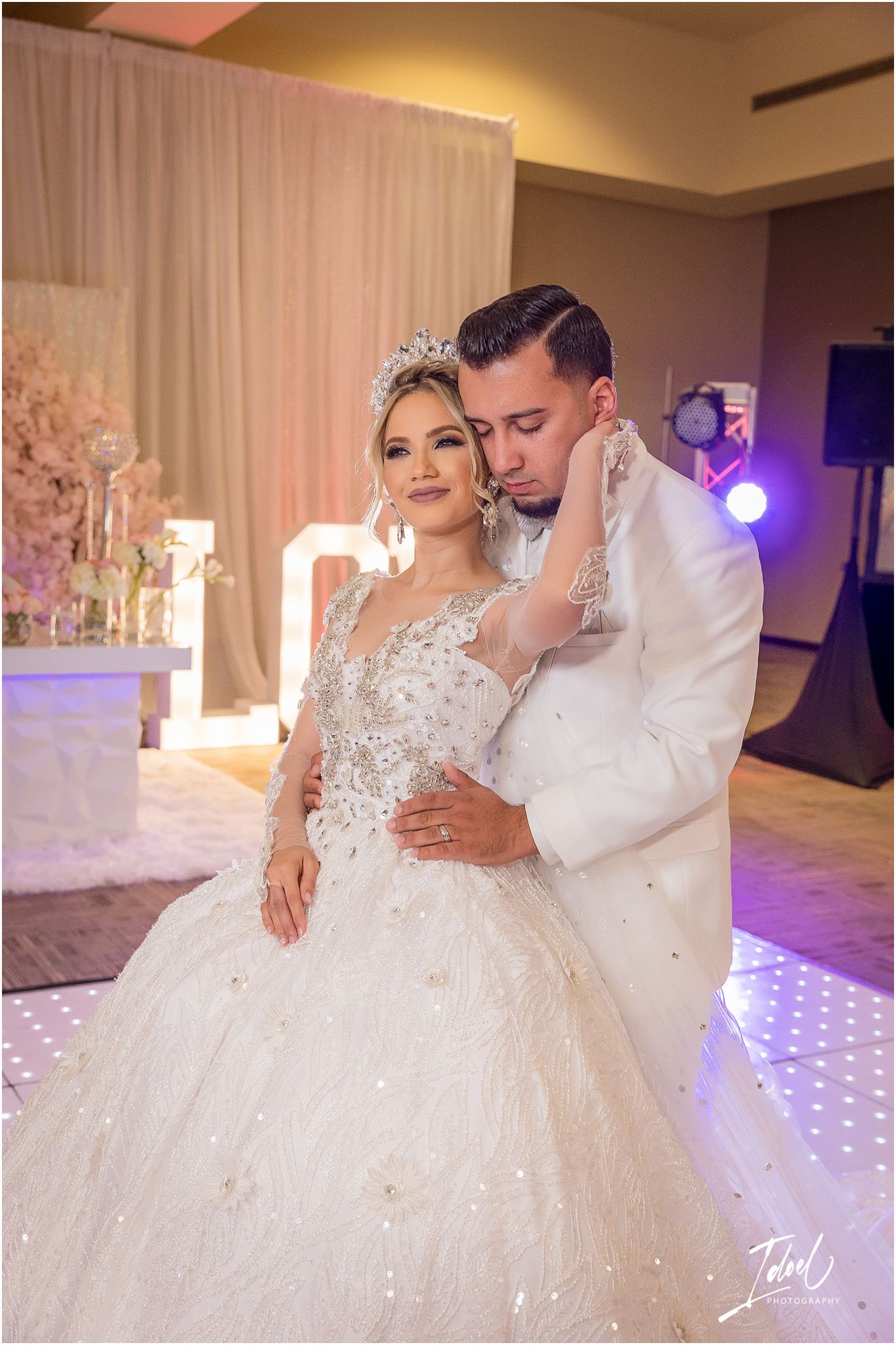 Intimate wedding dance moment on light-up floor with soft pink decor.