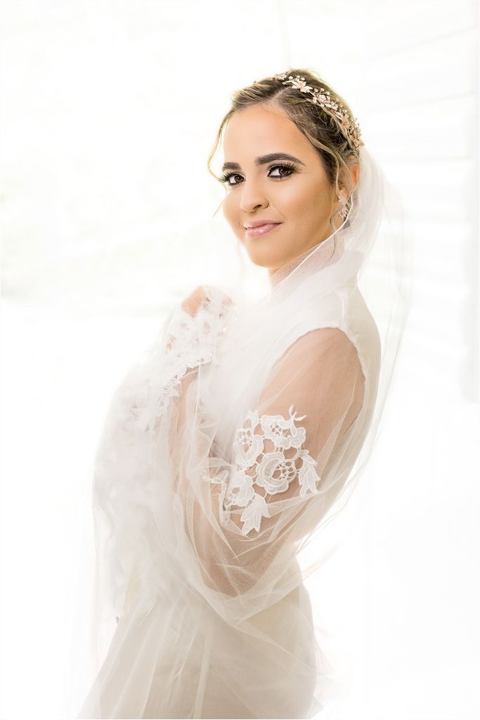 Ethereal bridal portrait with delicate lace veil and crystal headpiece.