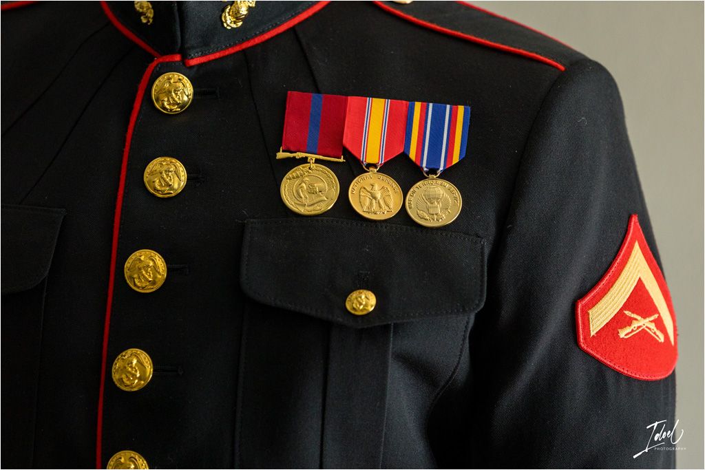 Close-up of a decorated Marine Corps dress uniform with medals and brass buttons.