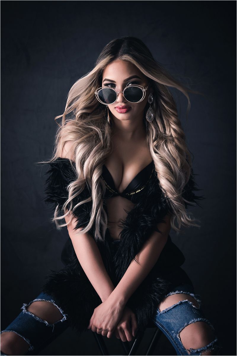 Artistic fashion portrait series showing model in black feathered top and ripped jeans against dark background.