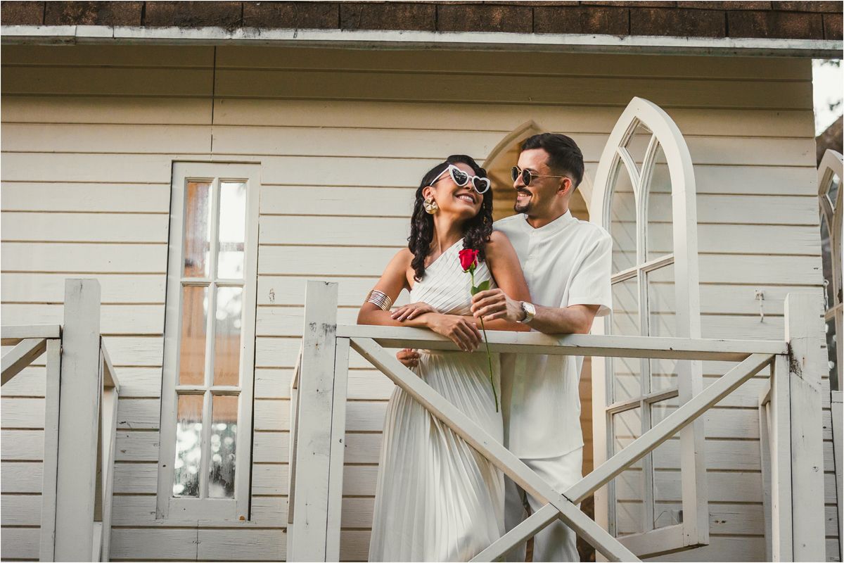 Romantic scene on a white cottage porch with architectural details and wooden railings.