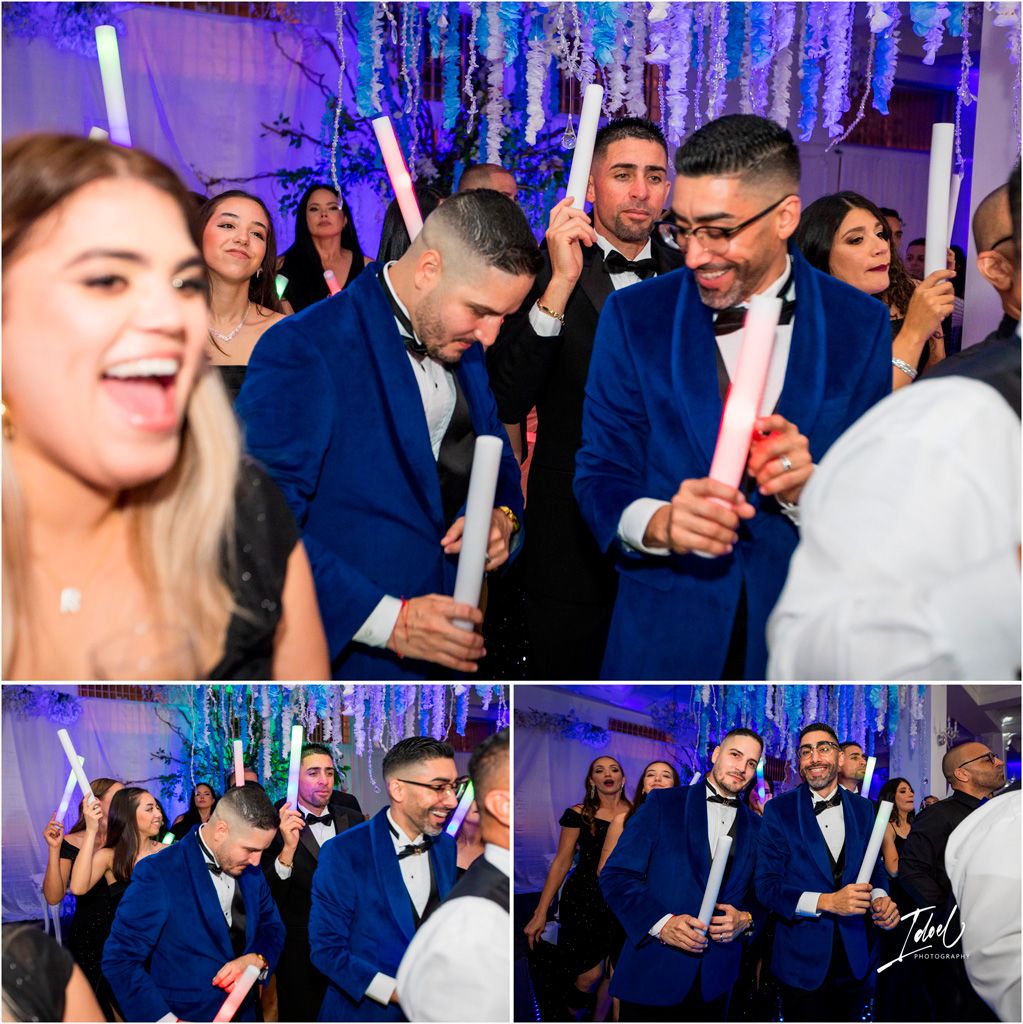 People dancing and celebrating at a wedding reception with blue lighting and light-up glow sticks on the dance floor.