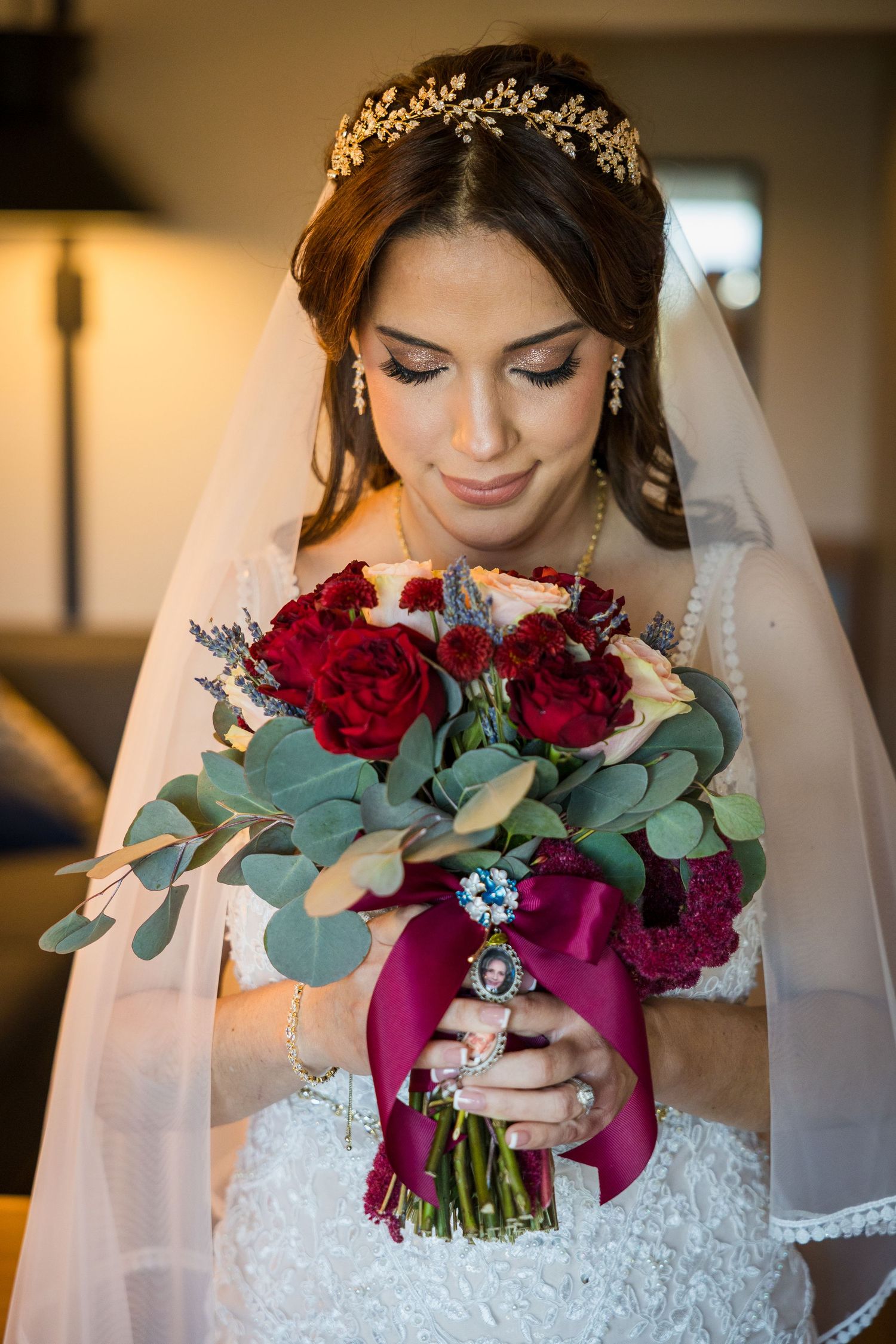 Deep red and burgundy wedding bouquet with eucalyptus leaves and romantic details.