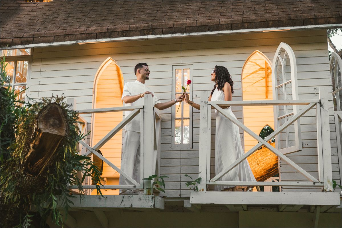 A sequence of photos showing a person falling backwards off a porch while holding an orange umbrella.
