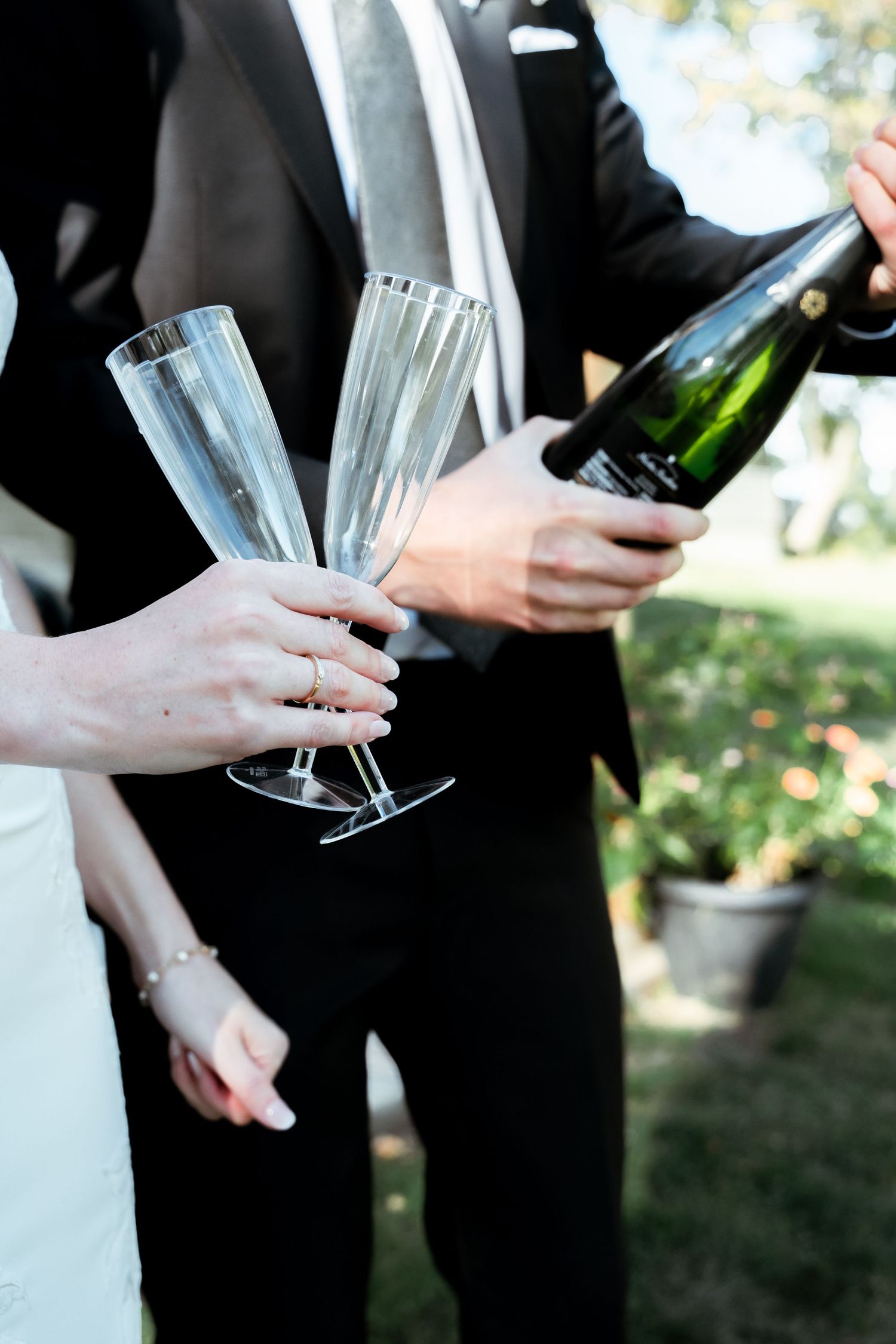 Close-up sequence of hands pouring and holding champagne glasses at a formal event.