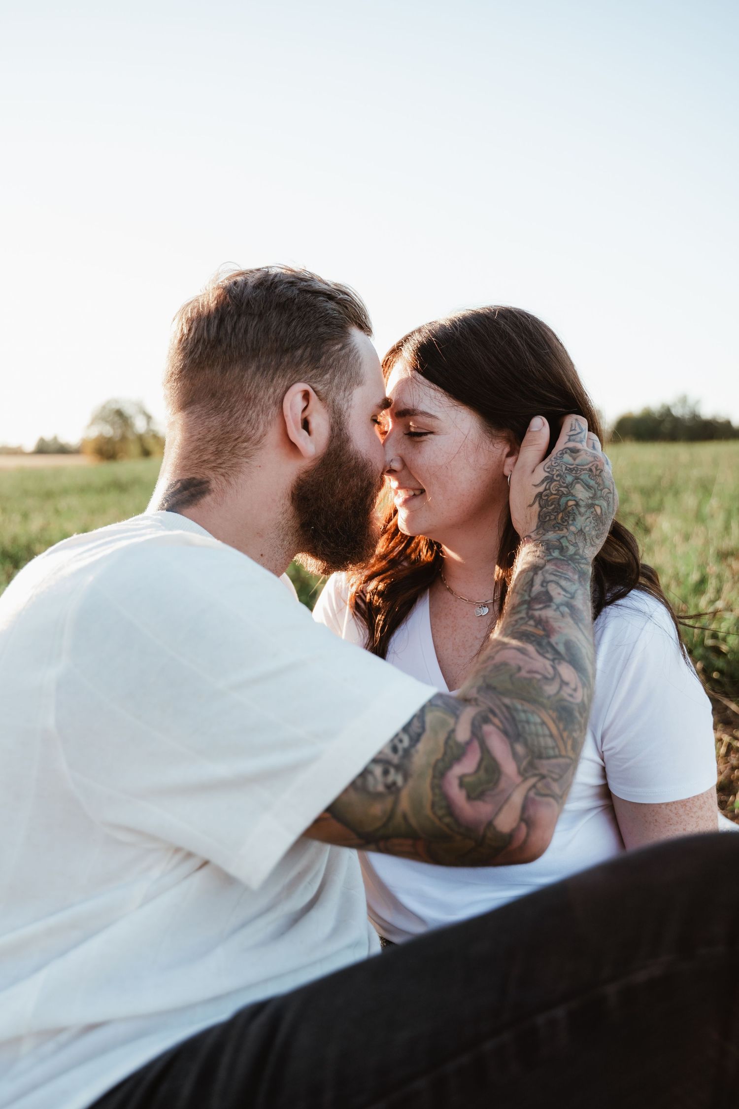 Romantic sunset portrait of couple sharing an intimate moment outdoors.