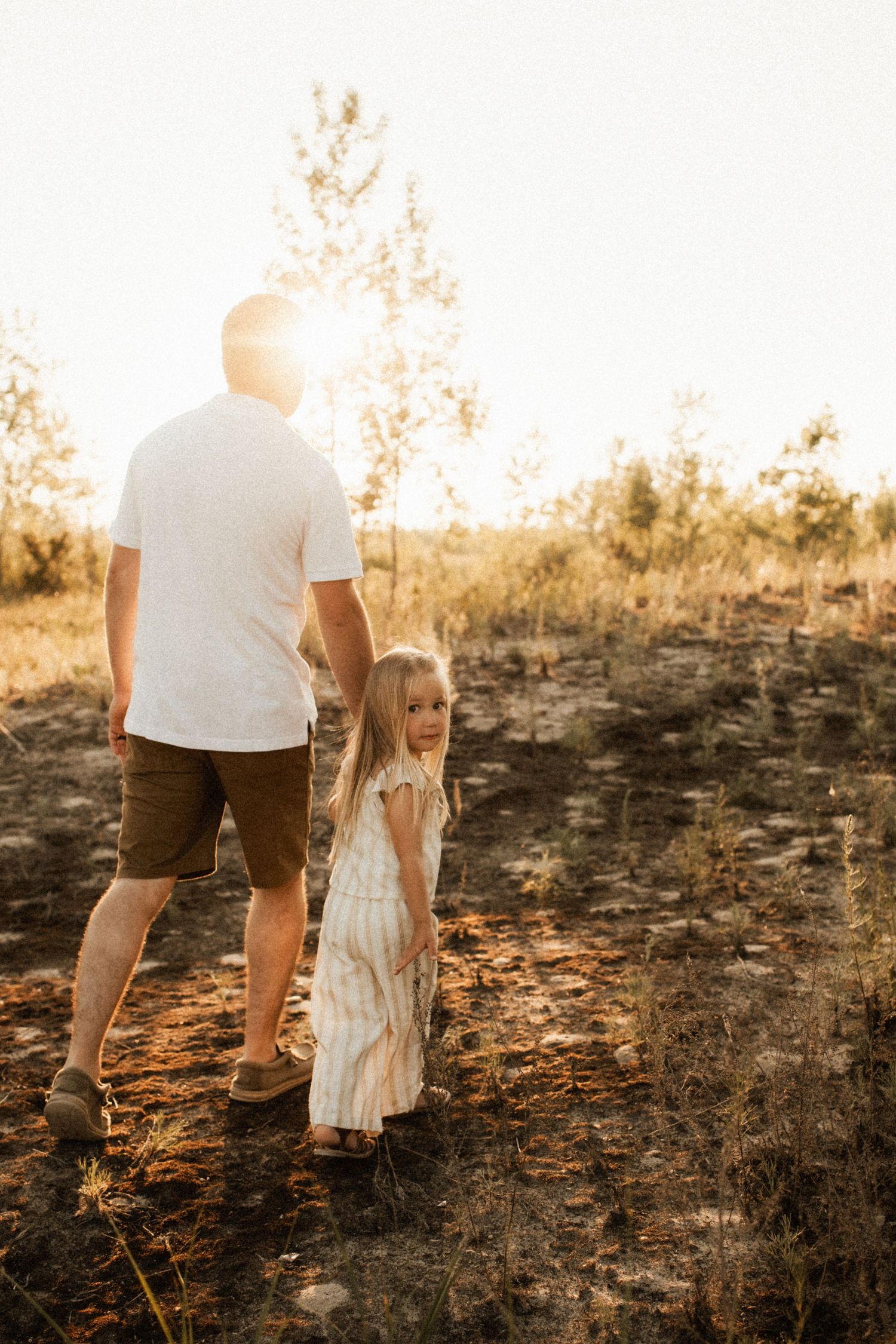 Silhouettes walking together at sunset on rugged terrain.
