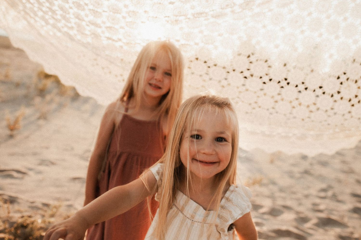 Candid moments captured on a sunny beach with lace umbrella.