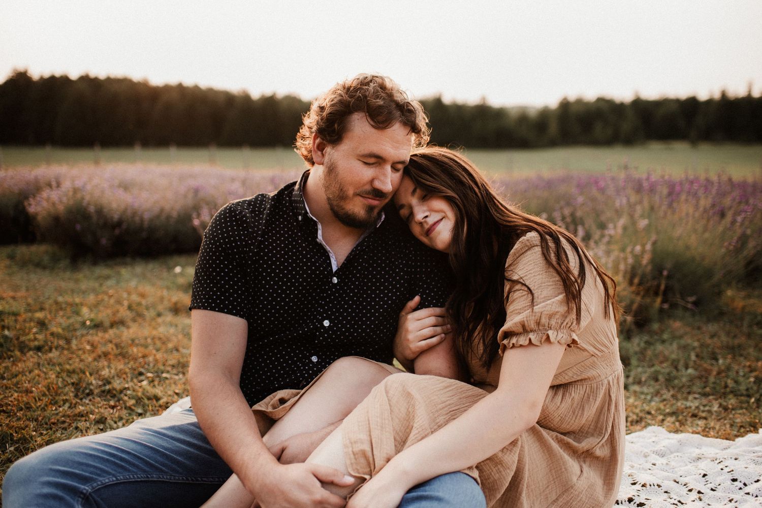 Intimate couple's portrait session in rustic field at sunset.