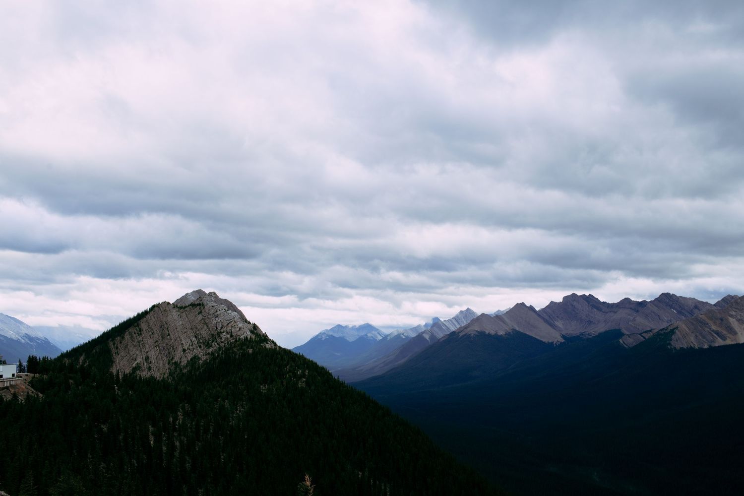 Dramatic mountain peaks under cloudy skies in a rugged wilderness landscape.