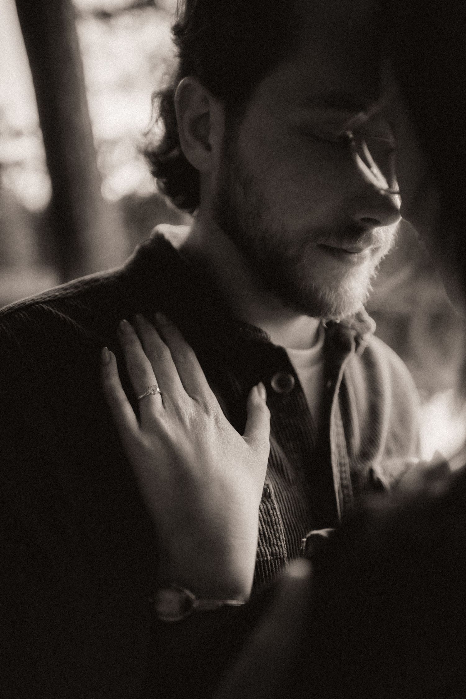 Moody black and white close-up portrait showing gentle touch and connection.