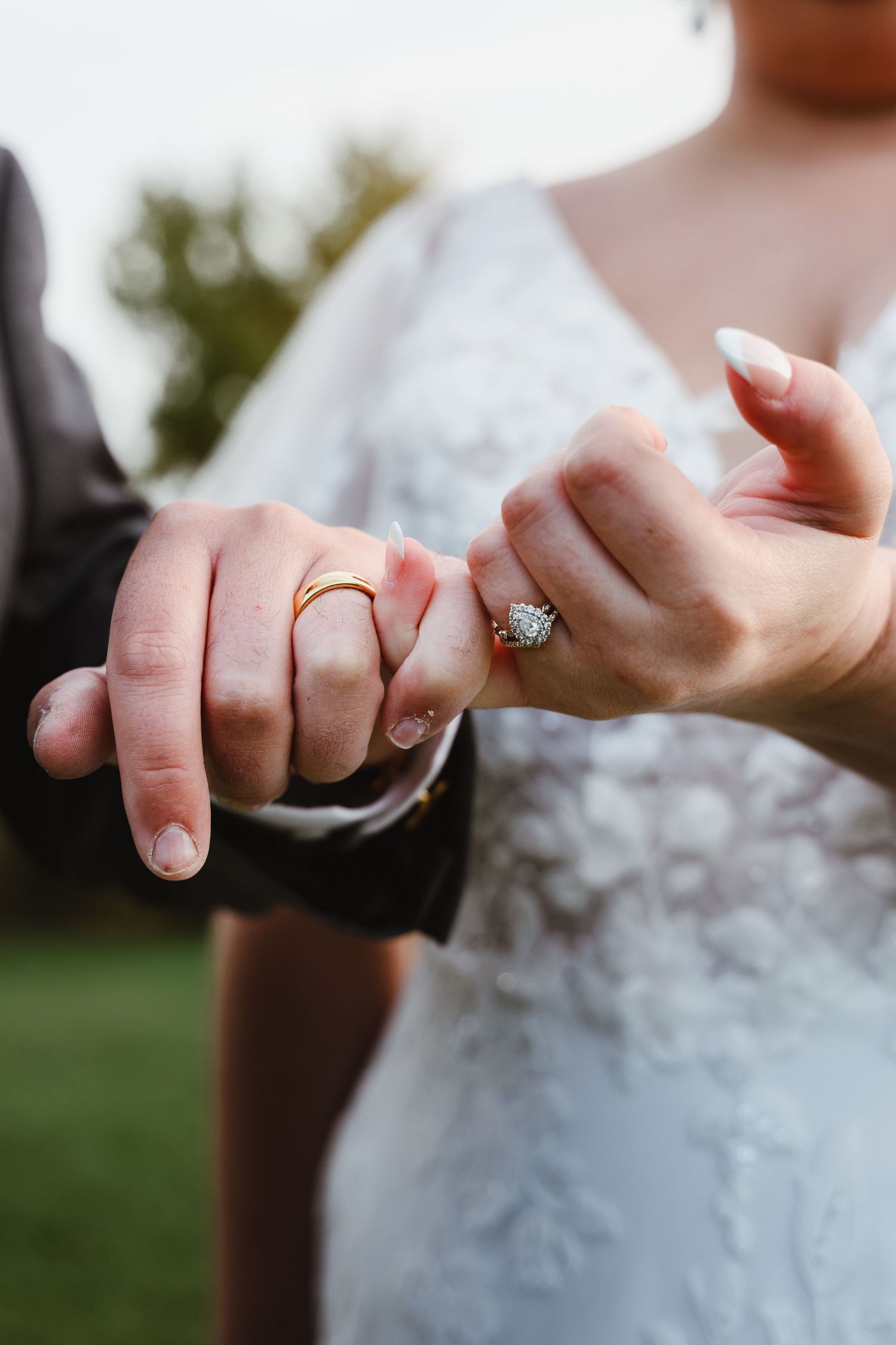 Close-up of bride's hand showing elegant engagement ring and wedding band.