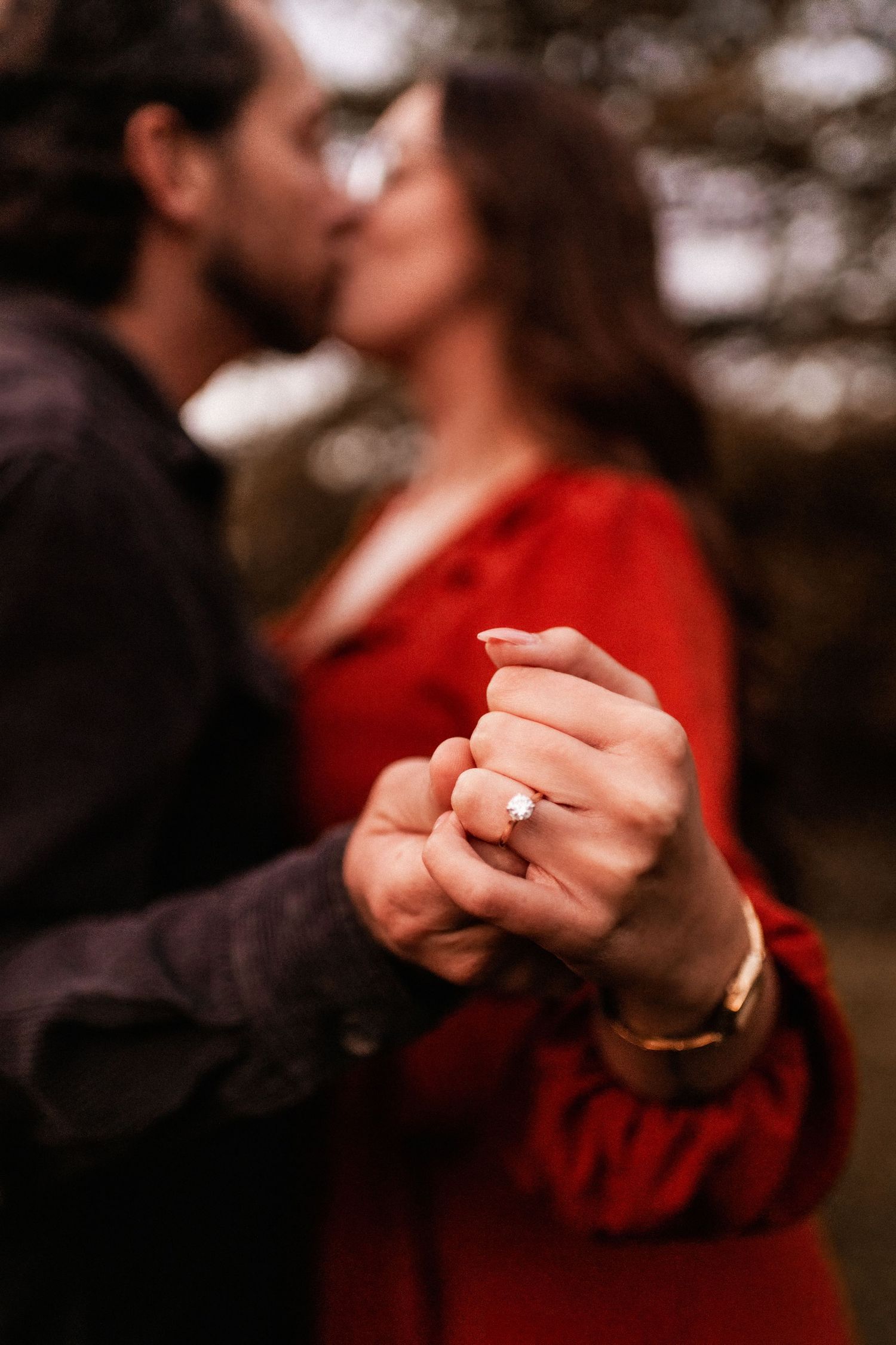 Close-up shots of hands displaying an engagement ring in a romantic outdoor setting.