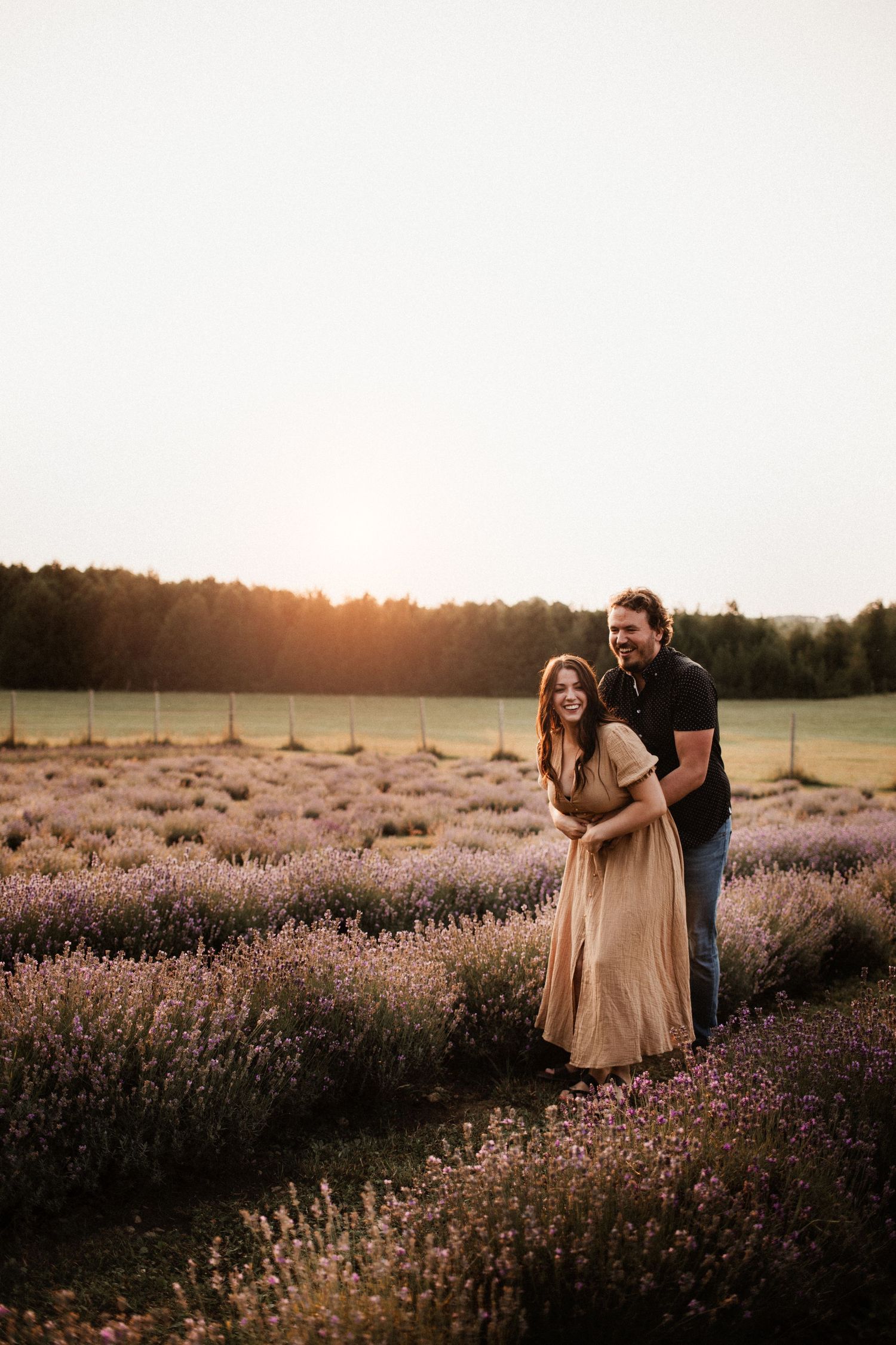 Couple sharing intimate moments in a purple lavender field during golden hour.