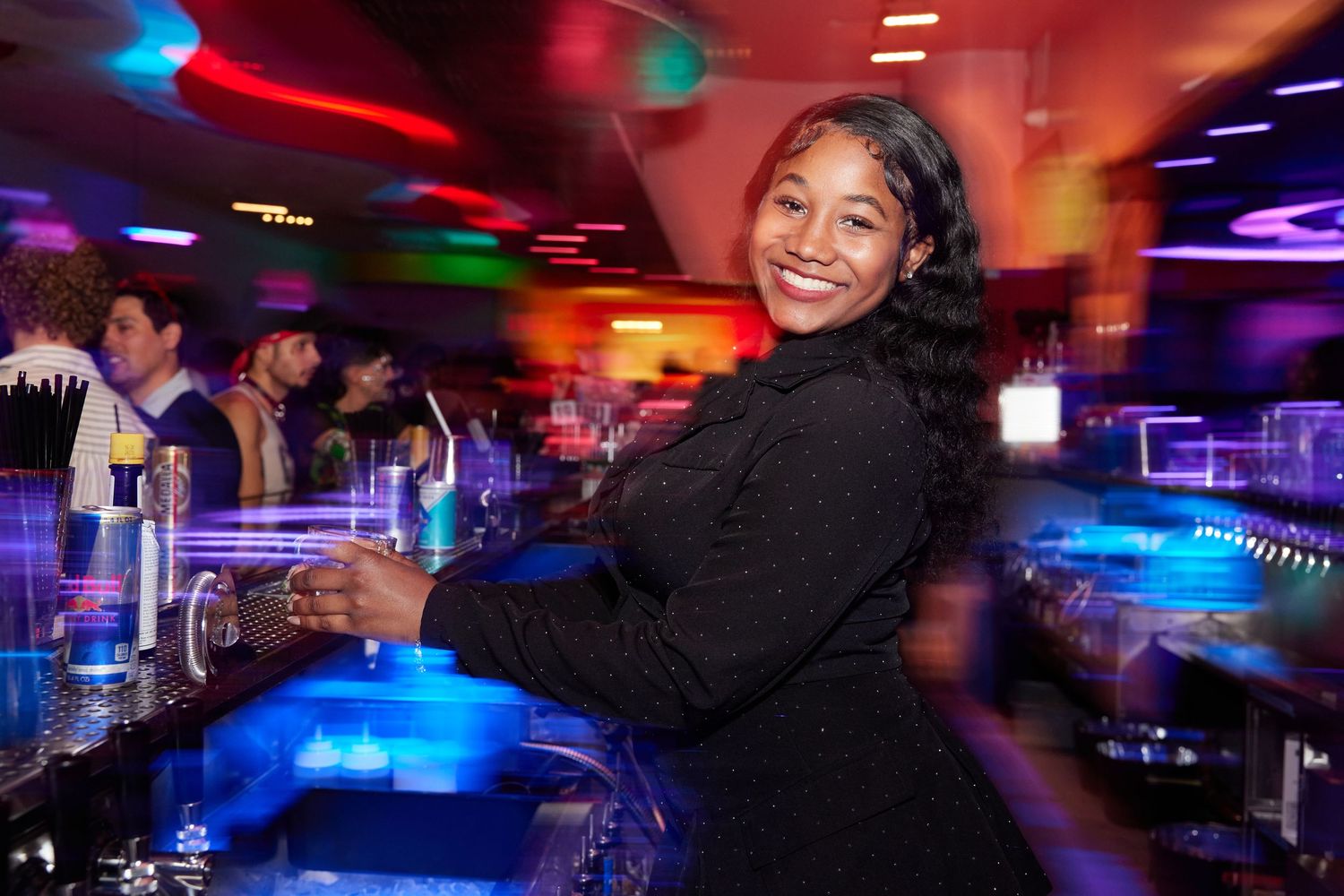 Bartender under colorful lighting at Xanadu Roller Arts with motion blur energy