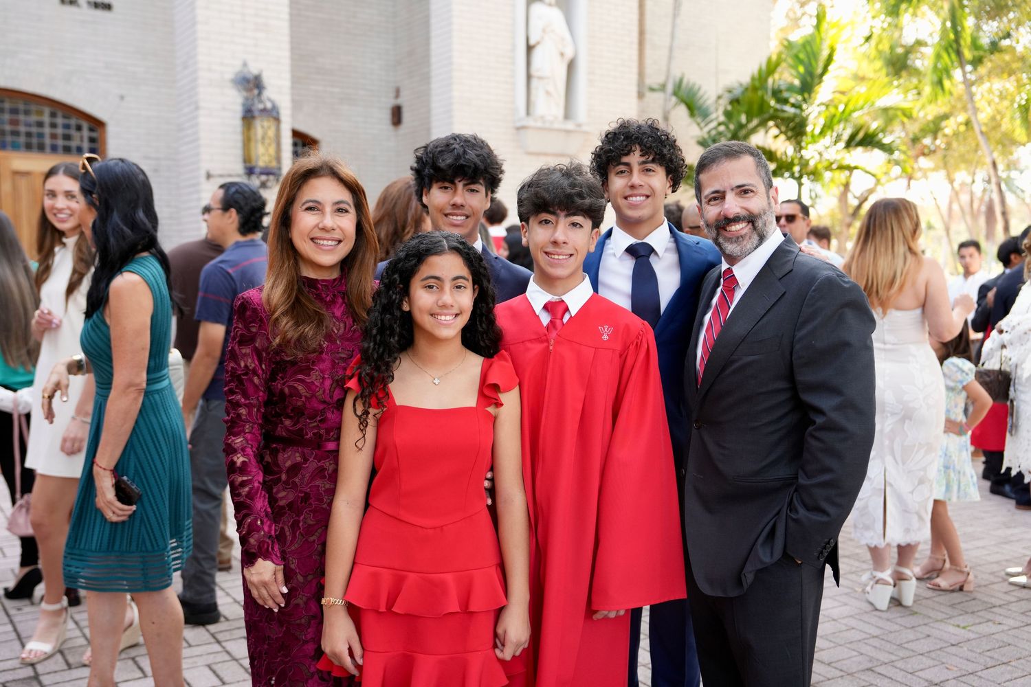 A happy family poses together outdoors at a ceremony celebration.