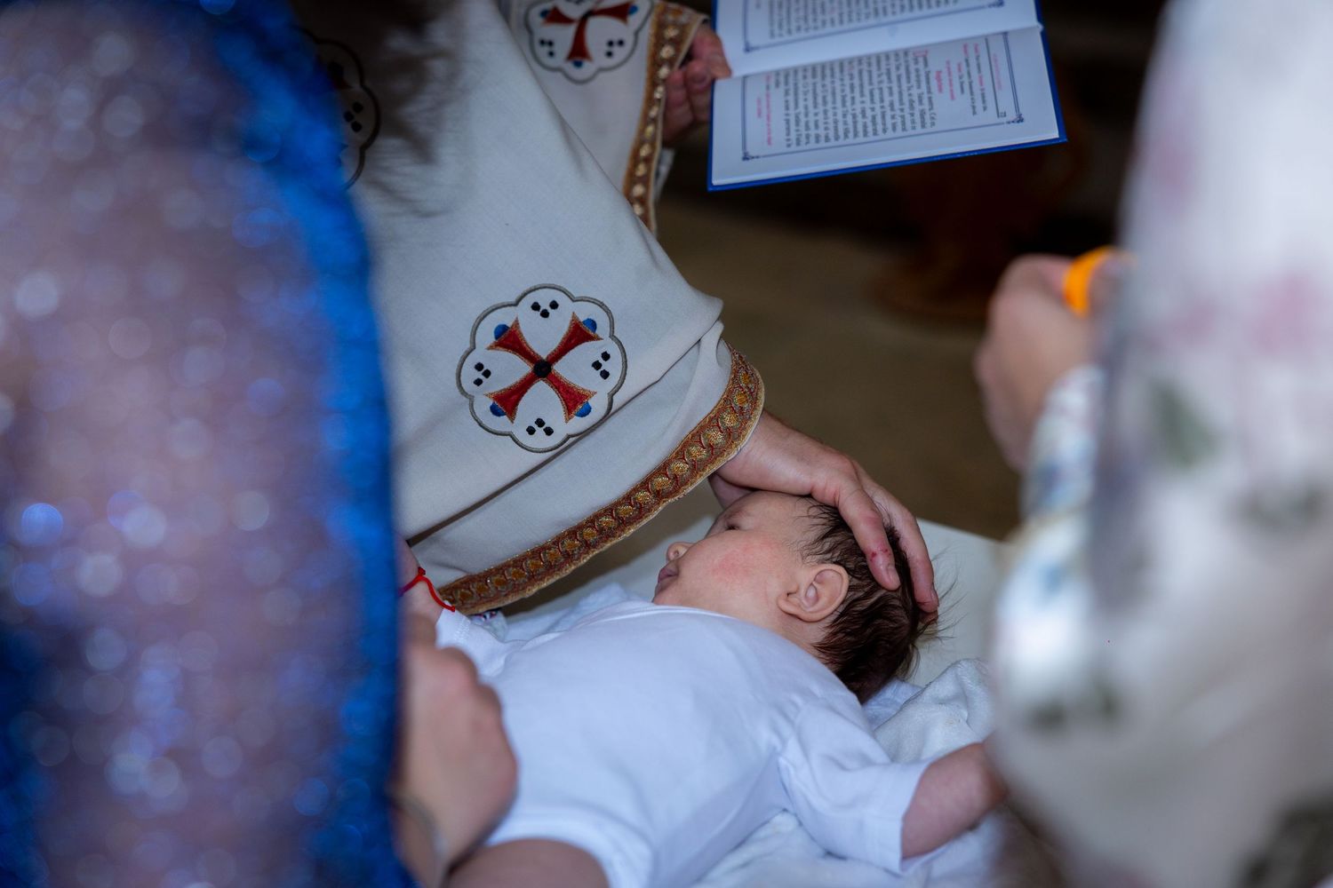 Der Priester beugt sich während der Zeremonie zu Emilia