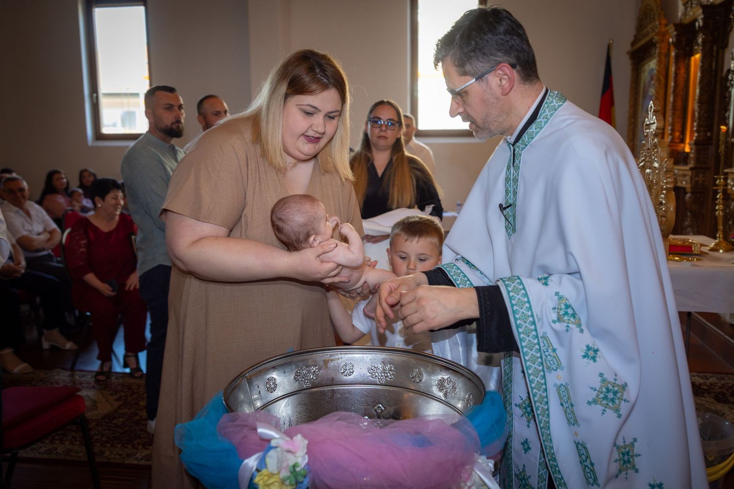 Der Priester tauft Liam Darius behutsam am Taufbecken