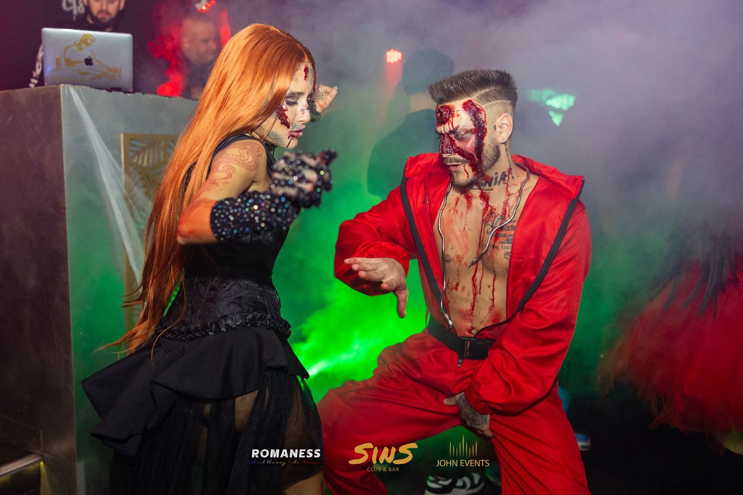 Zwei kostümierte Gäste tanzen an Halloween im grünen Licht des Club Sins.