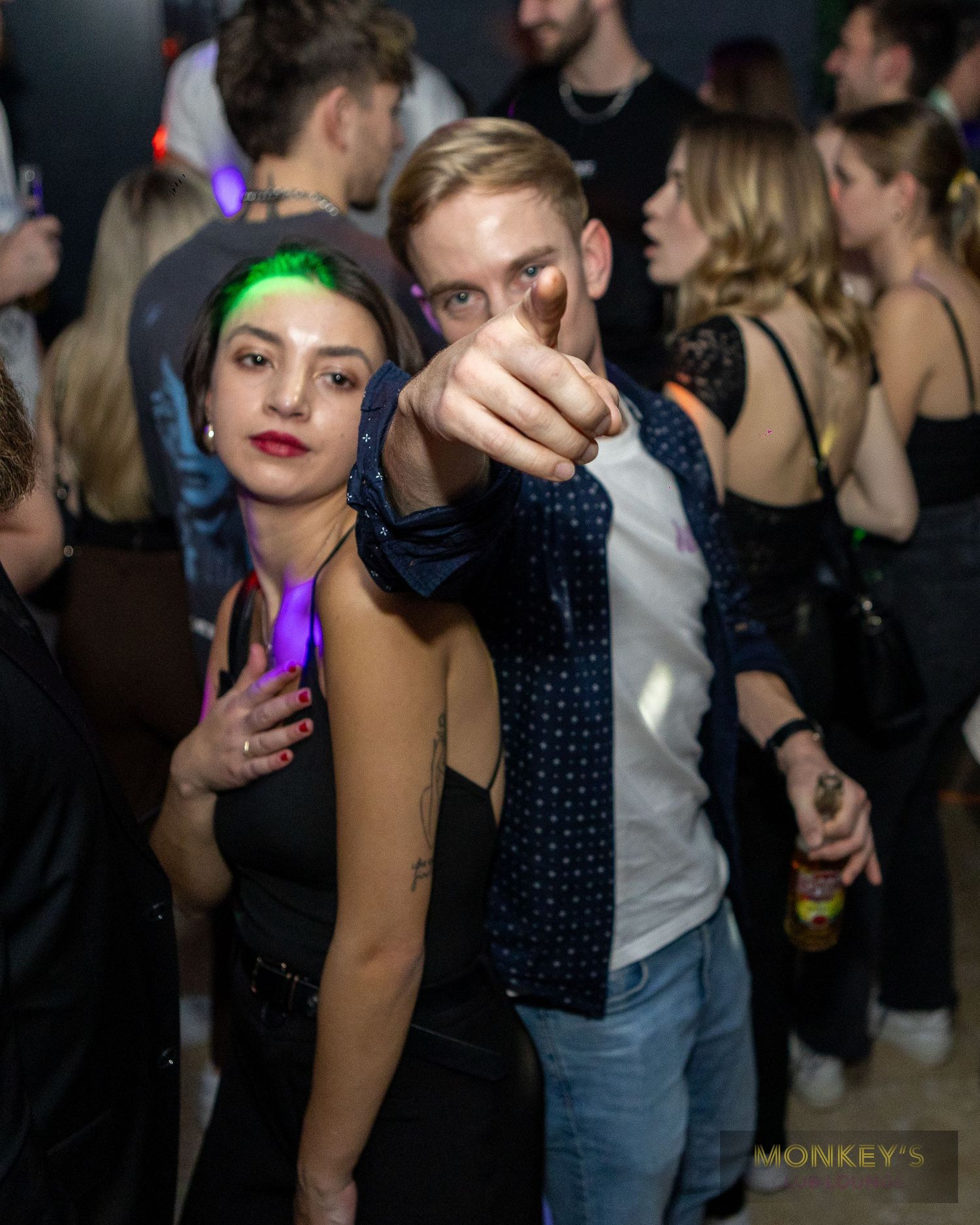 Ein Mann zeigt zur Kamera, neben ihm steht eine Frau im Monkey’s Club.