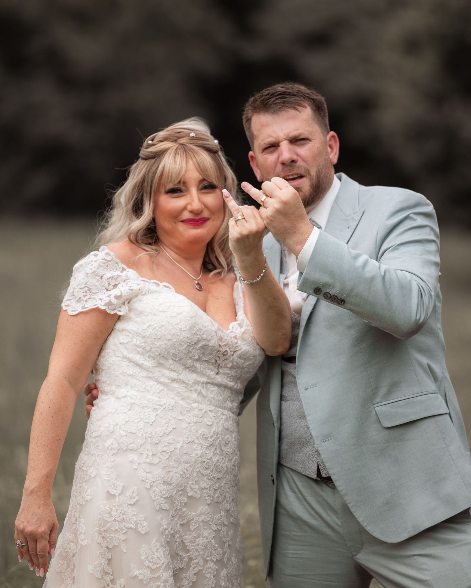 Marina und Ionuț zeigen bei ihrem Porträt auf der Wiese ihre Eheringe