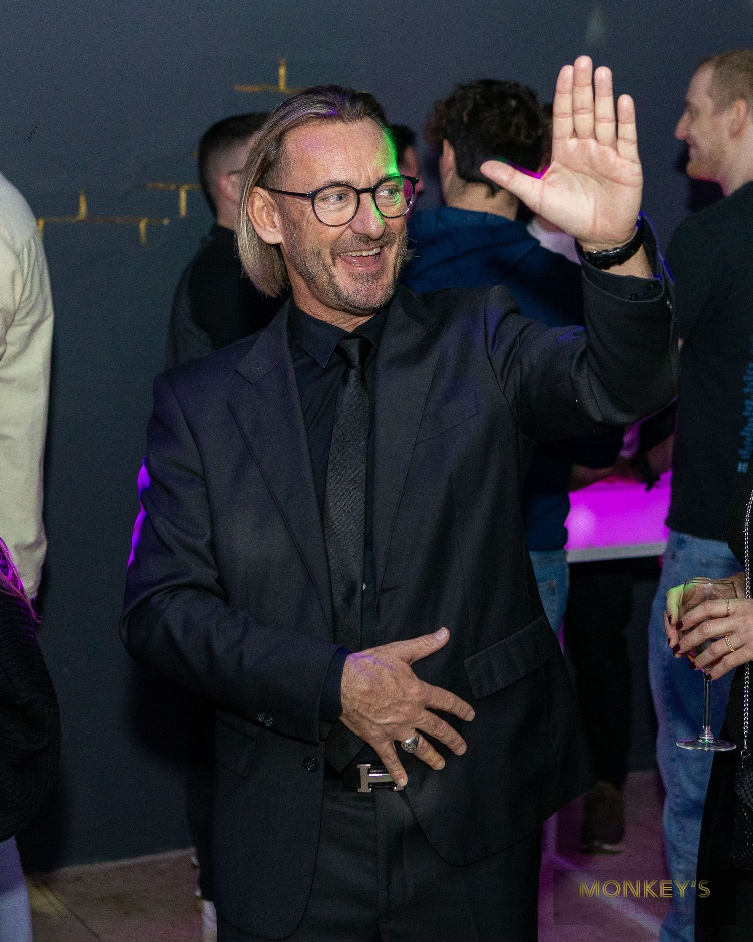 Ein Mann mit Brille hebt beim Tanzen im Monkey’s Club eine Hand.