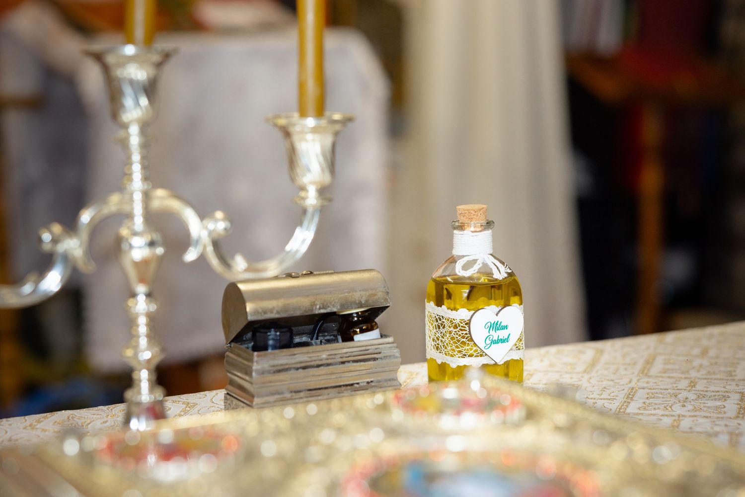 Fläschchen mit Salböl zwischen Kerzen und liturgischen Gegenständen