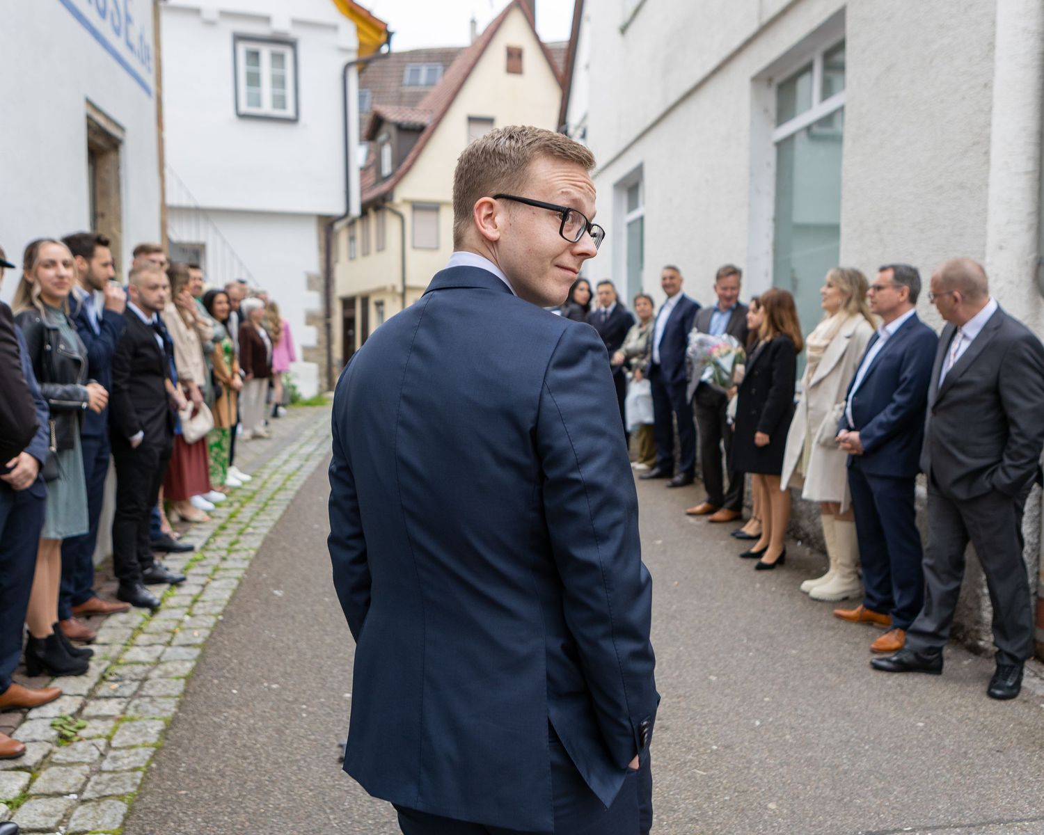 Stefan kommt an und geht zwischen den wartenden Gästen zur Zeremonie.