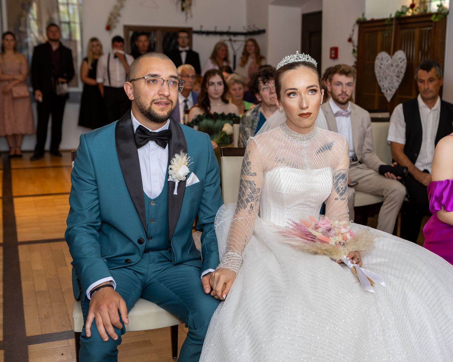 Radu und Saskia sitzen während der Trauung nebeneinander in der Kirche.