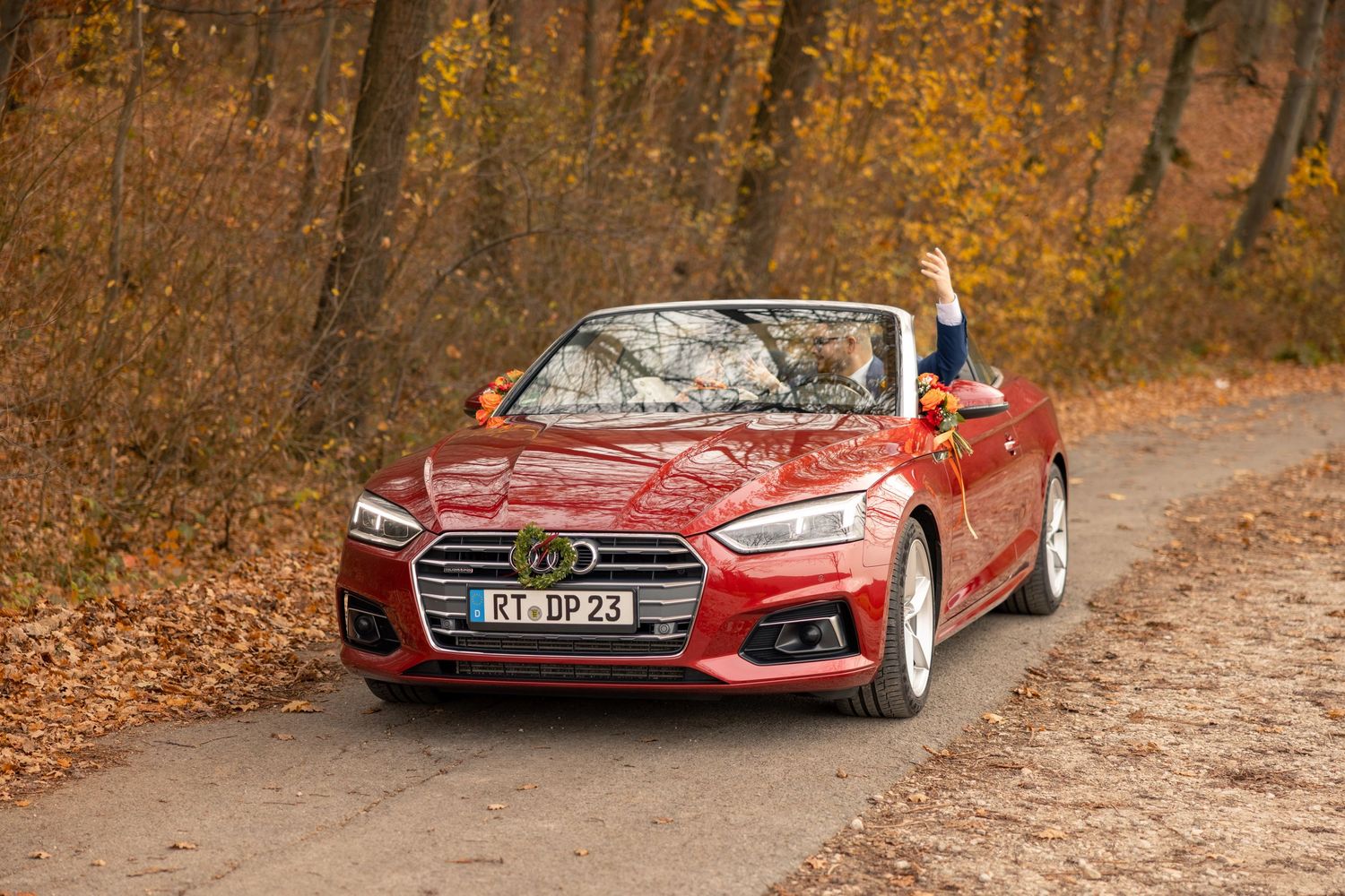 Diana und Leon am roten Cabriolet in der herbstlichen Landschaft