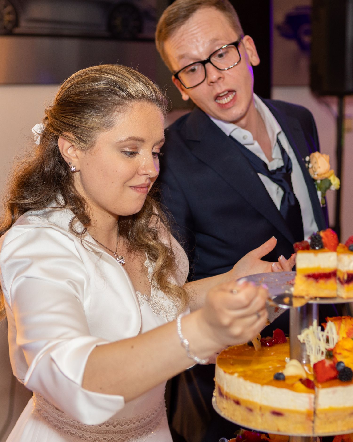 Sherry schneidet die Hochzeitstorte während der Feier an.