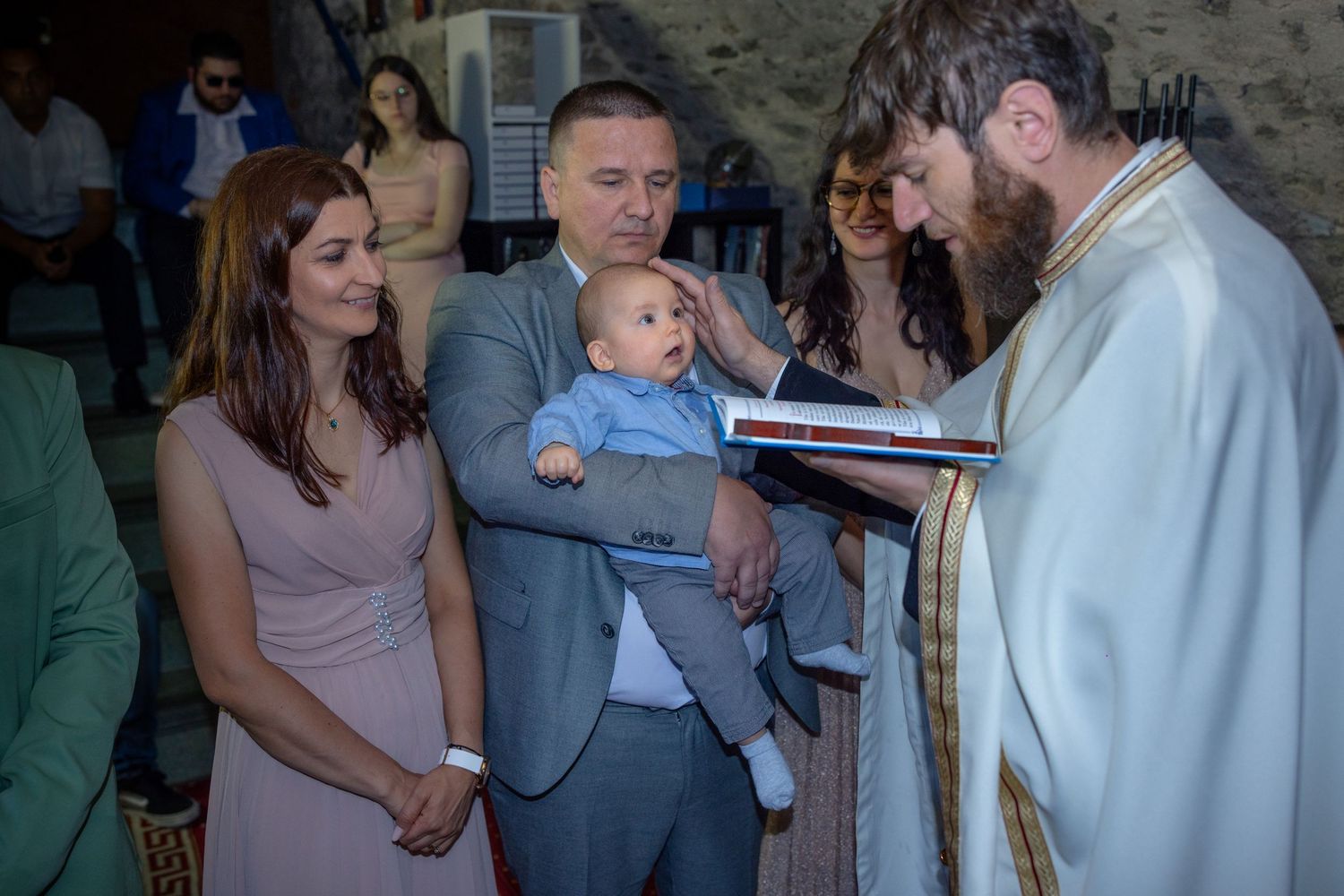 Milan schaut während des ersten Segens aufmerksam zum Priester