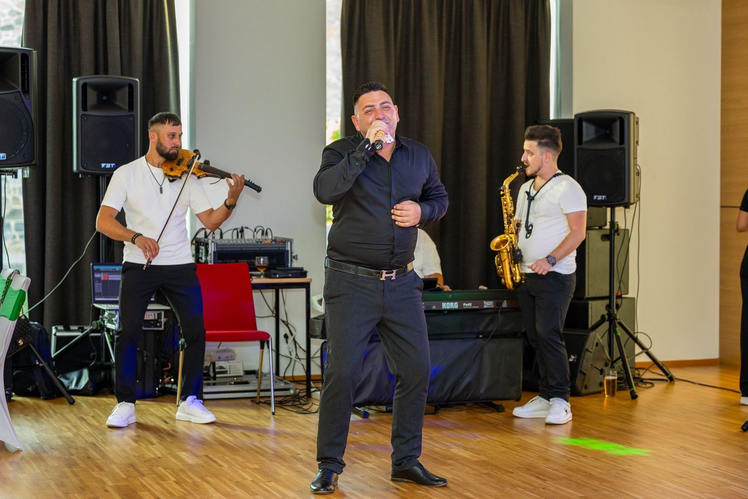 Ein Sänger steht mit Mikrofon vor Musikern bei der Feier.