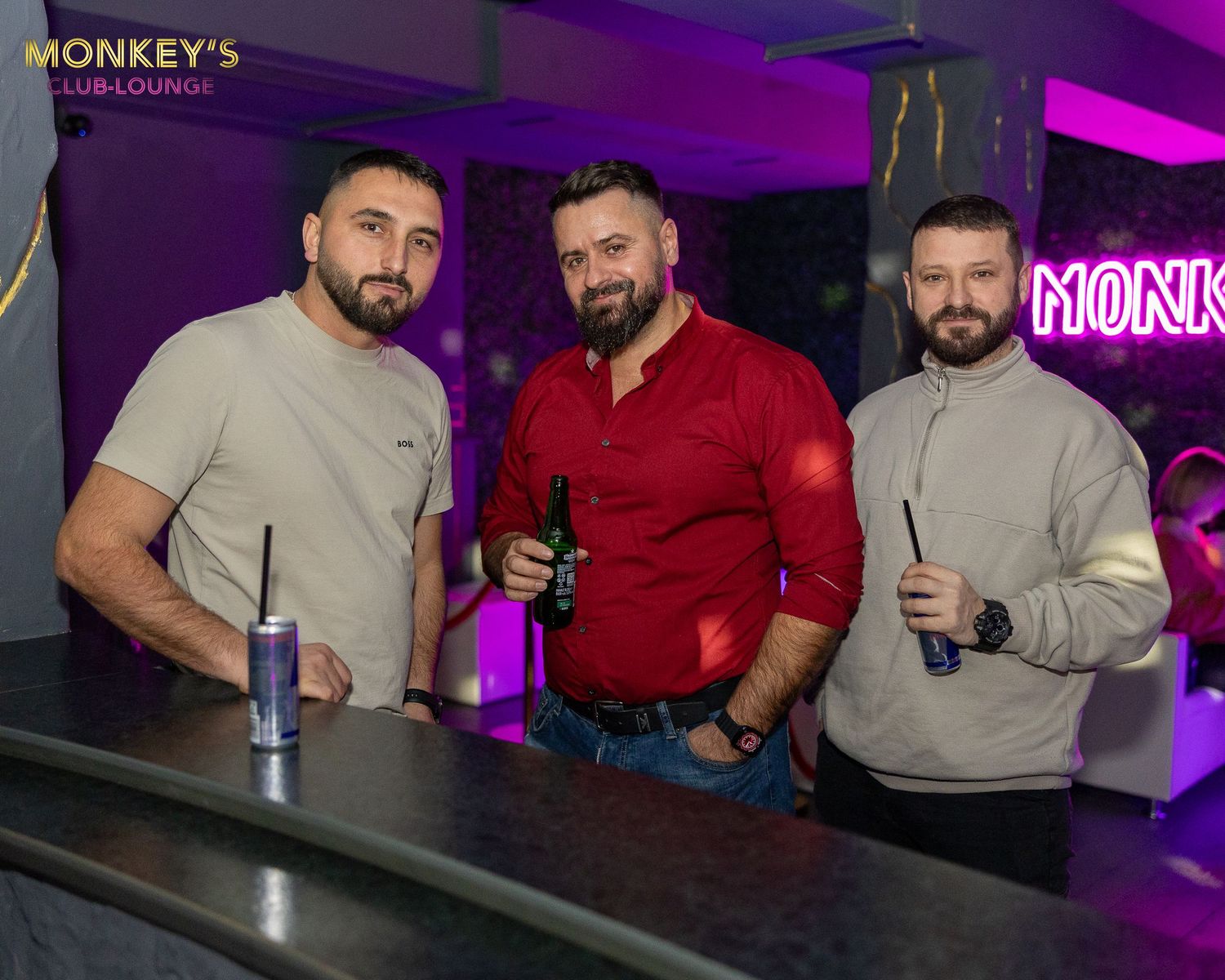 Drei Männer stehen gemeinsam an der Bar im Monkey’s Club.