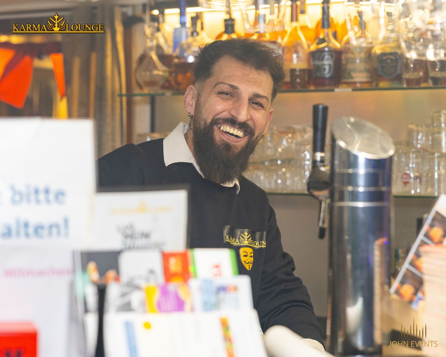 Ein Mitarbeiter lächelt hinter der Bar der Karma Lounge.