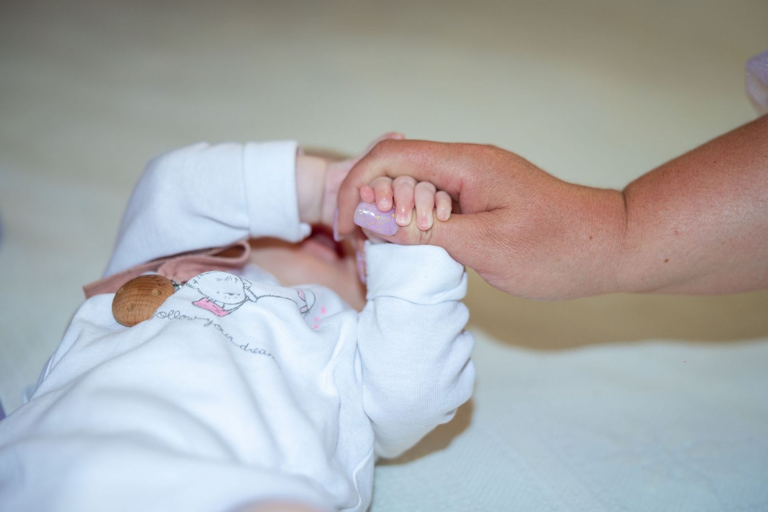 Alexia Ioana umfasst mit ihrer kleinen Hand einen Finger einer erwachsenen Person.