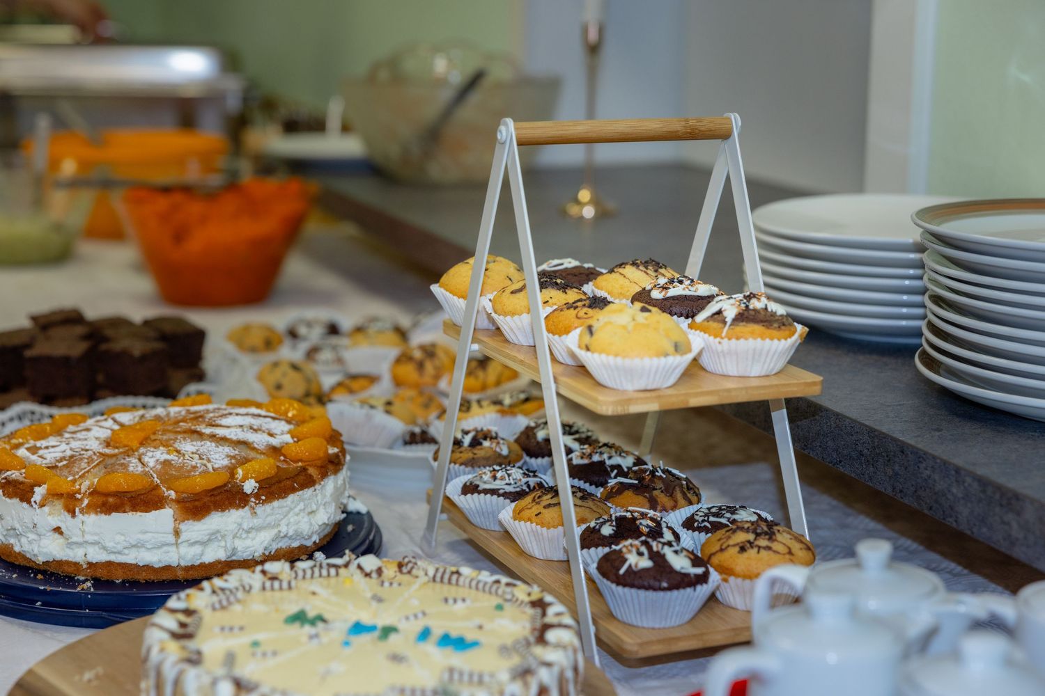 Kuchen und kleine Desserts stehen auf einem festlich vorbereiteten Buffet.