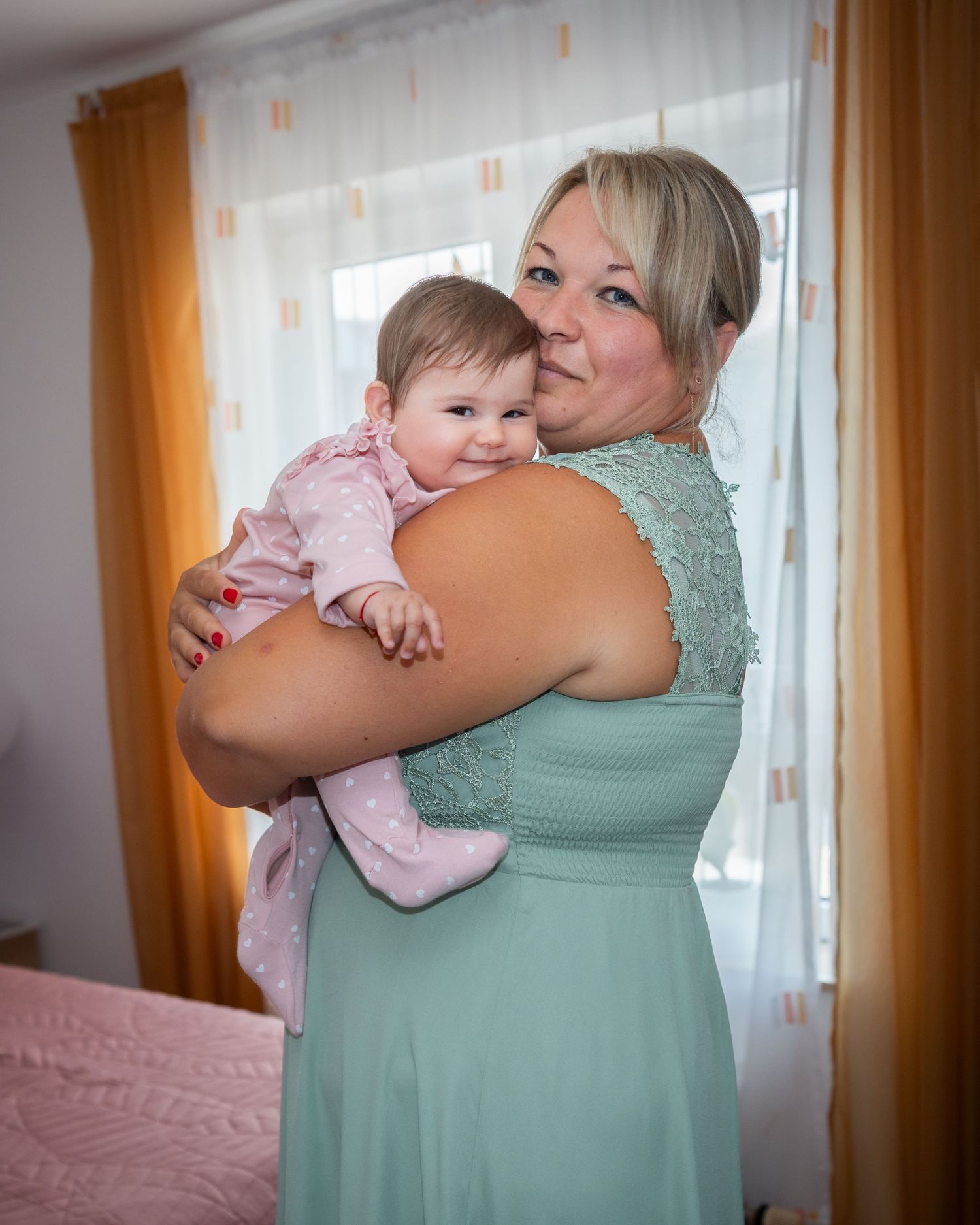 Karoline schaut über die Schulter einer Frau im mintfarbenen Kleid.