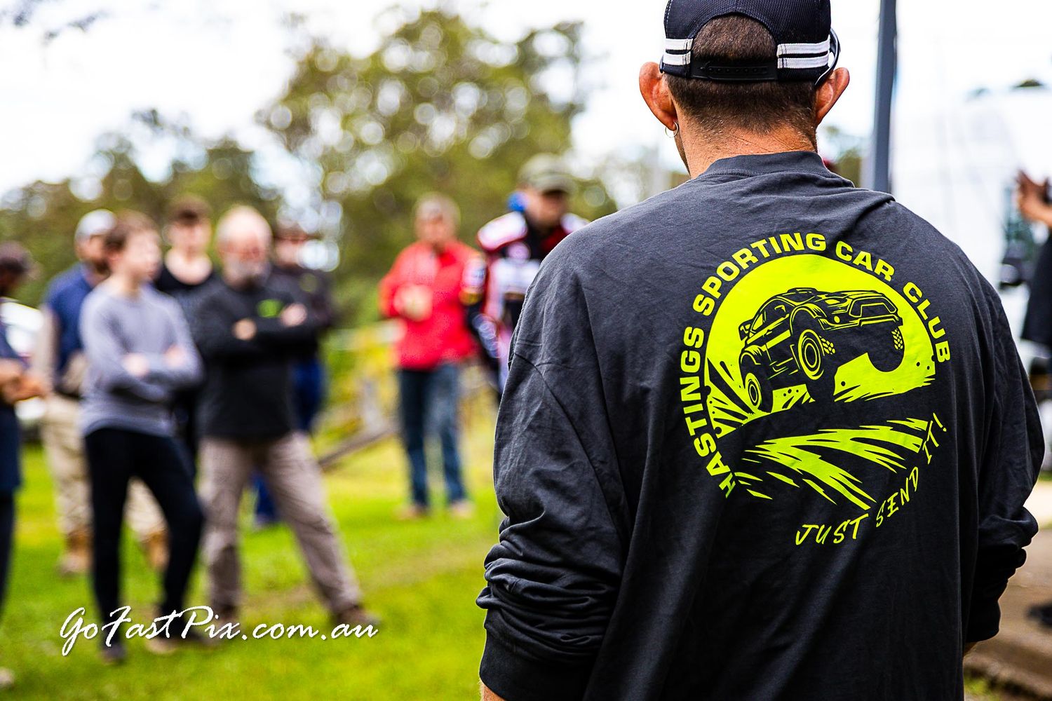 Person wearing Hastings Sporting Car Club black jacket at an outdoor motorsport event in Australia.