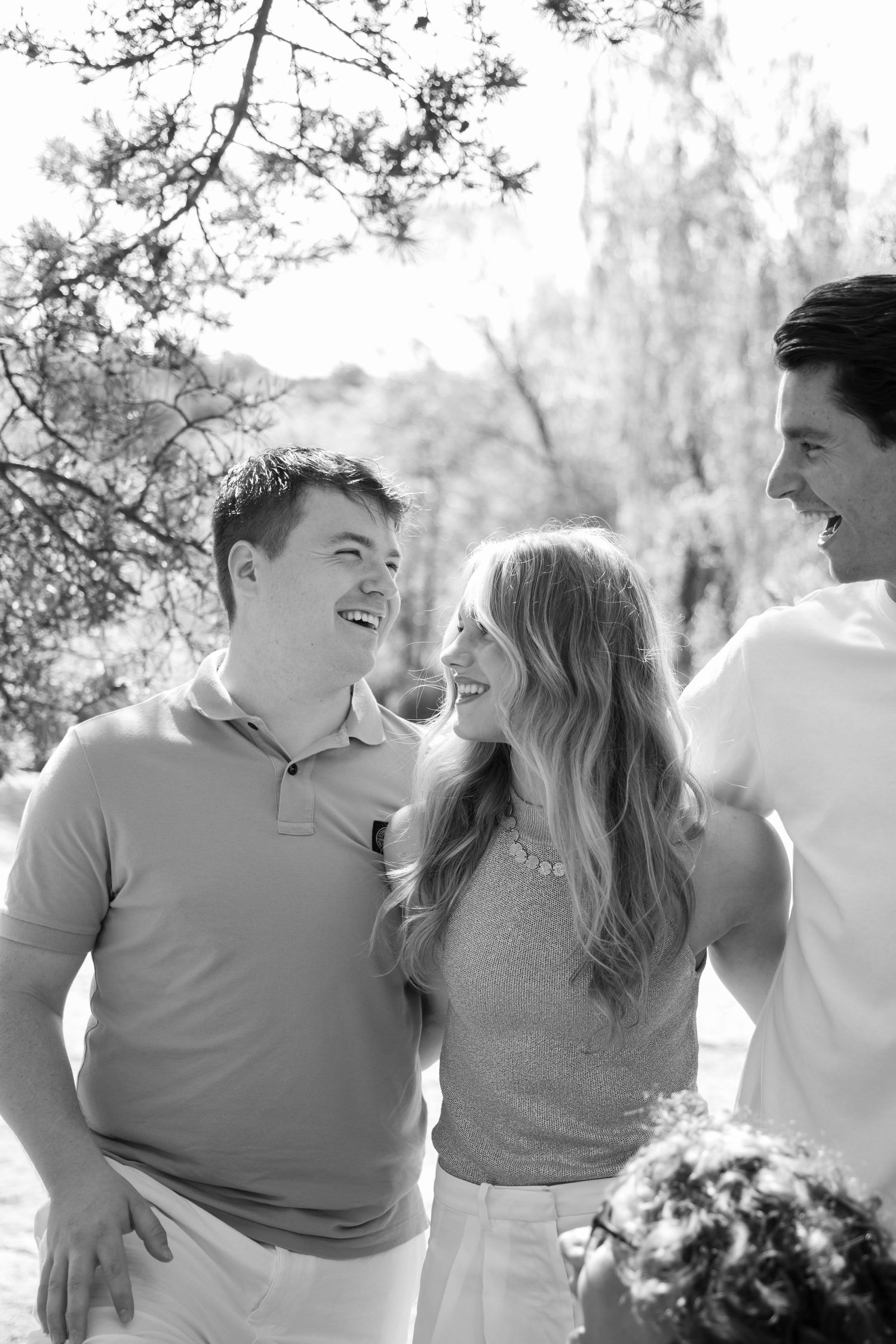 Black and white photo of three smiling young adults laughing together outdoors among trees.
Familie Wormgoor - Familieshoot